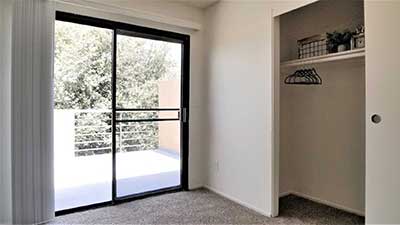Broadway Apartments bedroom, closet, and balcony with sliding glass door